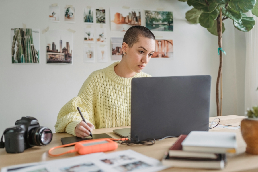 Ragazza davanti al computer che scrive e sperimenta le grafiche editoriali e fotografiche