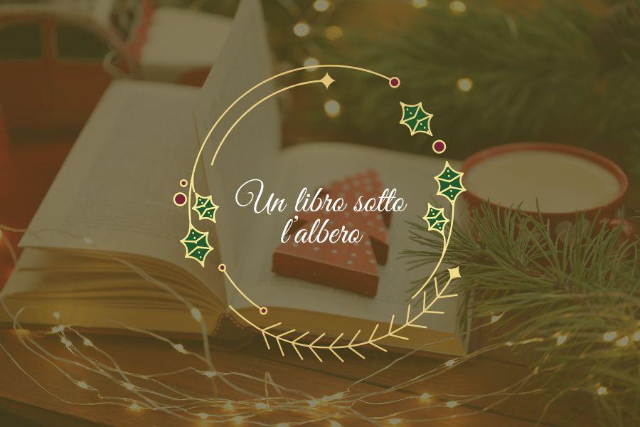 Sfondo verde scuro, in trasparenza un libro sotto un albero di Natale. La scritta "Un libro sotto l'albero" è incorniciata da un cerchio decorato con l'agrifoglio.