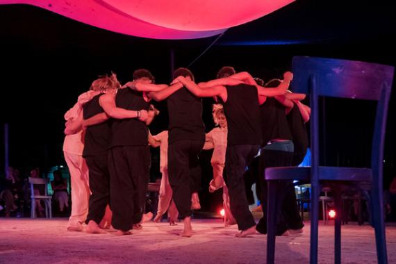 Foto di un gruppo di giovani persone in cerchio che danzano.