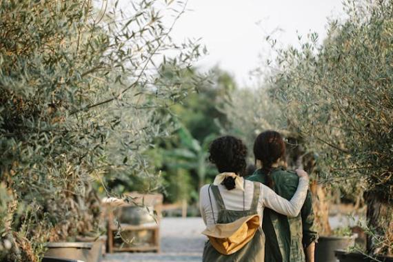 Due ragazze che passeggiano in un sentiero in mezzo alle piante