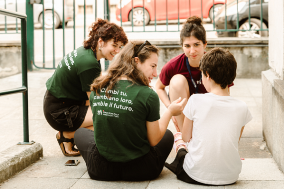 Gruppo di ragazze/insegnanti che supportano i/le loro alunni/e